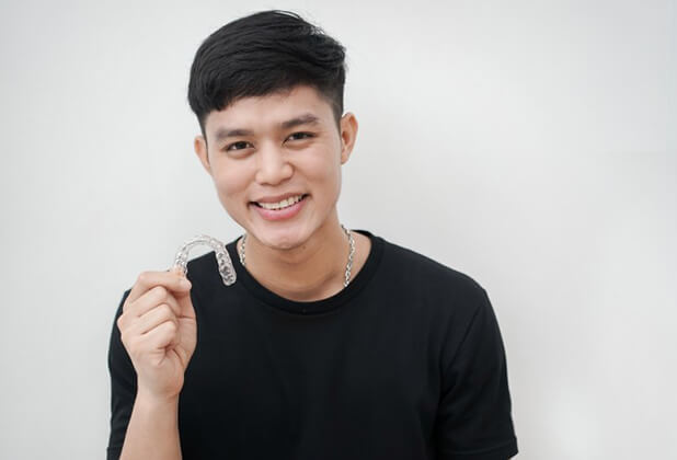 young man holding a tray for Invisalign® in Beverly Hills