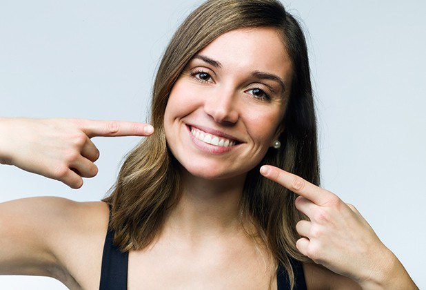 Woman pointing at her attractive smile