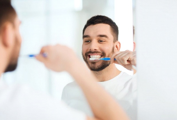 man brushing his teeth