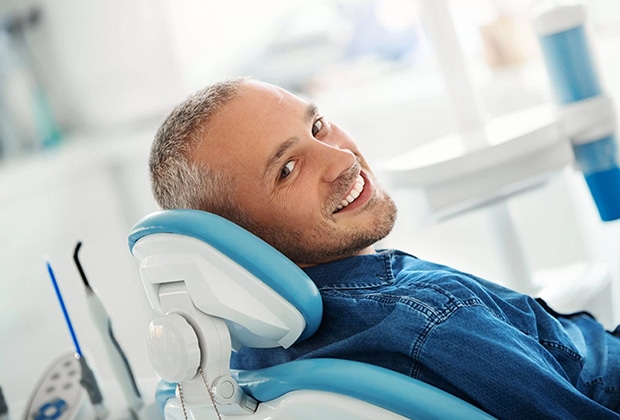 A cosmetic dentist in Beverly Hills using a shade guide to determine the color of a patient’s veneers