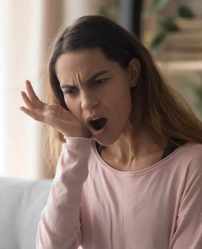 Woman in need of emergency dentistry holding her jaw